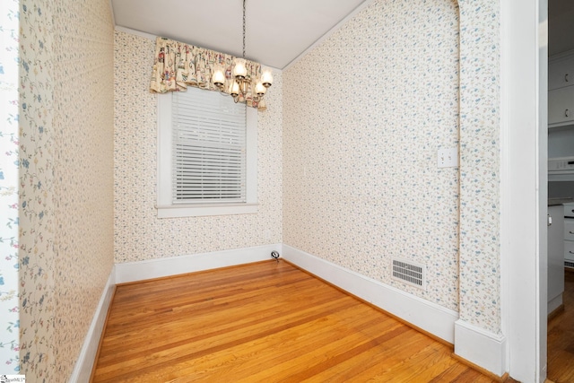 306 Mcdaniel Ave, Greenville, SC 29601 - unfurnished dining area with wood finished floors, a chandelier, wallpapered walls, and lofted ceiling