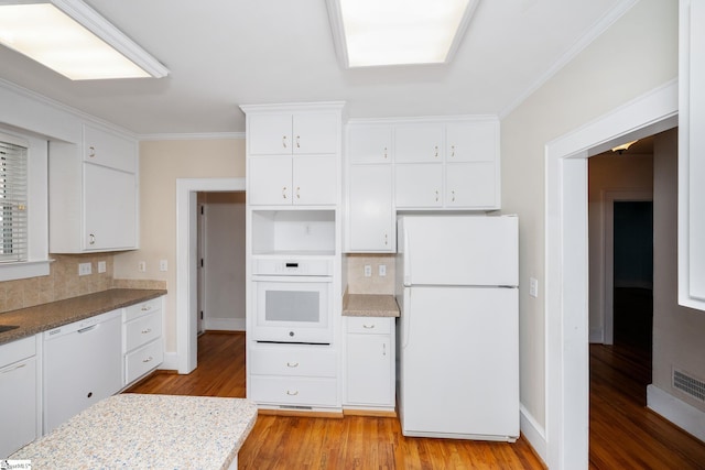 306 Mcdaniel Ave, Greenville, SC 29601 - kitchen with white appliances, backsplash, light wood-type flooring, crown molding, and white cabinets