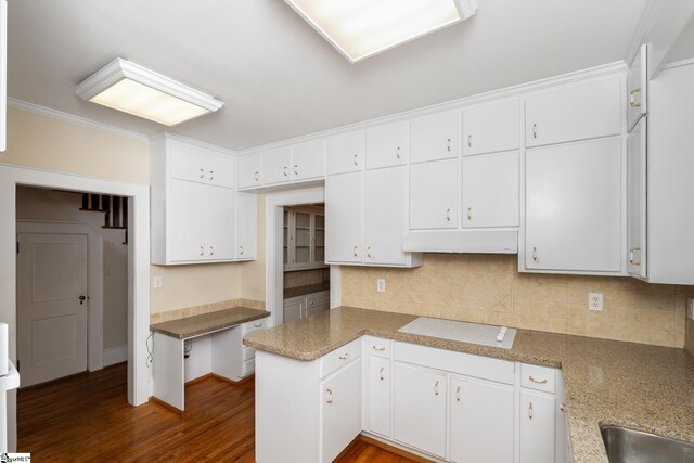 306 Mcdaniel Ave, Greenville, SC 29601 - kitchen with stovetop, under cabinet range hood, tasteful backsplash, dark wood finished floors, and white cabinetry