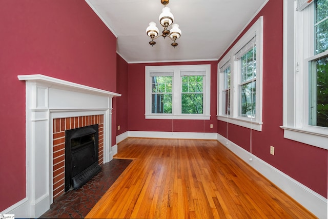 306 Mcdaniel Ave, Greenville, SC 29601 - unfurnished living room featuring a fireplace, wood-type flooring, a chandelier, and ornamental molding
