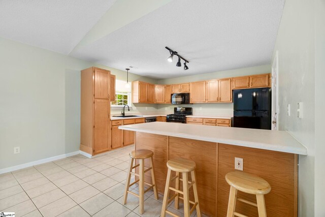 210 Admiral Ln, Greer, SC 29650 - kitchen with black appliances, a peninsula, light countertops, and a kitchen bar