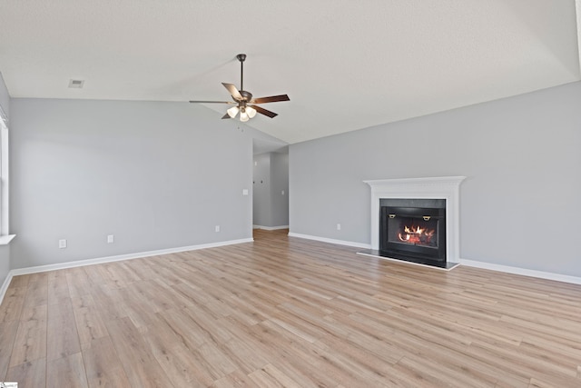 29 Parkgate Ct, Simpsonville, SC 29680 - unfurnished living room with a ceiling fan, light wood finished floors, lofted ceiling, and a glass covered fireplace