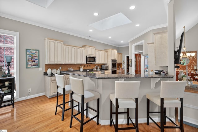 109 Tall Ship Dr, Anderson, SC 29625 - kitchen with appliances with stainless steel finishes, a skylight, a peninsula, a breakfast bar, and backsplash