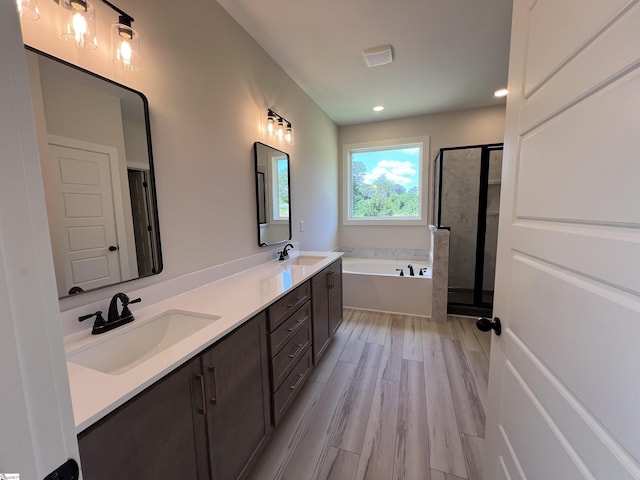3352 Earls Bridge Rd, Easley, SC 29640 - bathroom featuring a garden tub, double vanity, a stall shower, wood finished floors, and recessed lighting