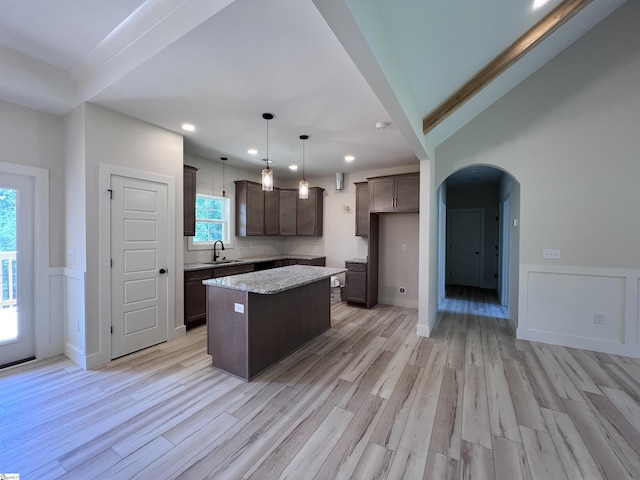 3352 Earls Bridge Rd, Easley, SC 29640 - kitchen with arched walkways, a kitchen island, dark brown cabinetry, recessed lighting, and light wood-style flooring