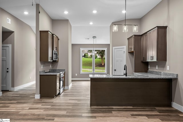 156 Grand Oak Cir, Pendleton, SC 29670 - kitchen with appliances with stainless steel finishes, dark brown cabinetry, a peninsula, light stone counters, and light wood-style floors