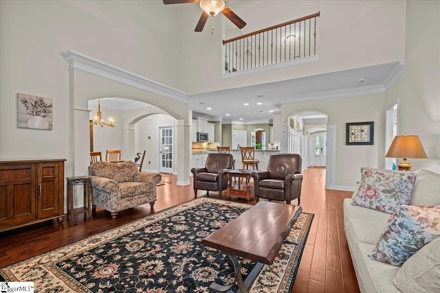 228 Holstein Ct, Fountain Inn, SC 29644 - living area with arched walkways, ornamental molding, wood-type flooring, a ceiling fan, and a high ceiling