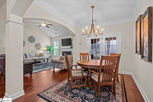 228 Holstein Ct, Fountain Inn, SC 29644 - dining room featuring arched walkways, dark wood-style floors, a fireplace, a chandelier, and crown molding