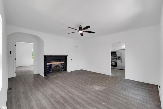 17 Smythe St, Pelzer, SC 29669 - unfurnished living room featuring a ceiling fan, dark wood finished floors, a fireplace, and arched walkways