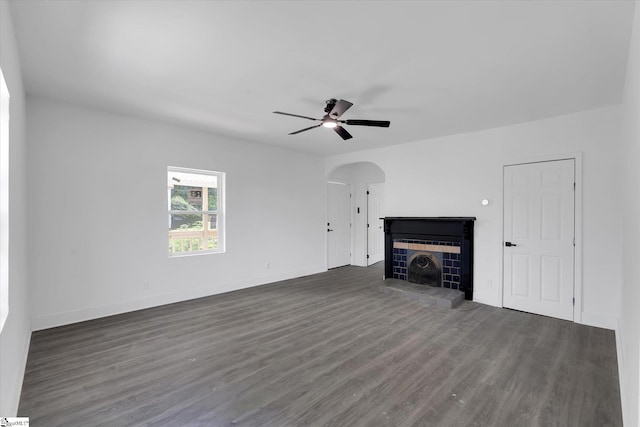 17 Smythe St, Pelzer, SC 29669 - unfurnished living room with arched walkways, a tiled fireplace, dark wood-style floors, and ceiling fan