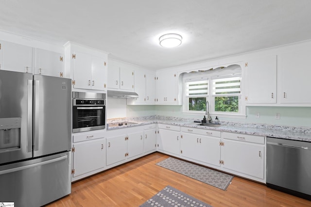 1142 Cooper Bridge Rd, Woodruff, SC 29388 - kitchen featuring appliances with stainless steel finishes, light wood-type flooring, white cabinetry, light stone counters, and under cabinet range hood