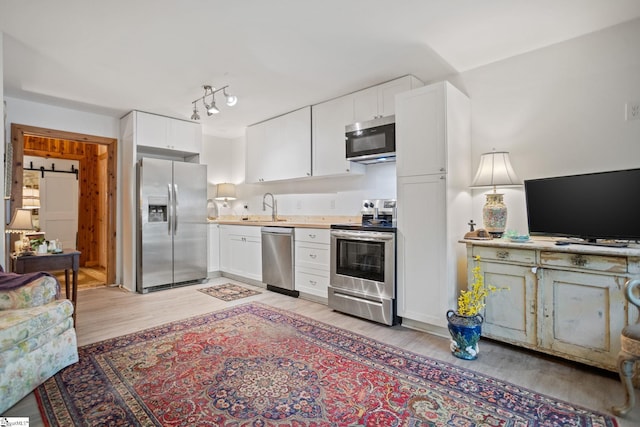 207 Sassafras Dr, Taylors, SC 29687 - kitchen featuring appliances with stainless steel finishes, light wood-type flooring, white cabinetry, and light countertops