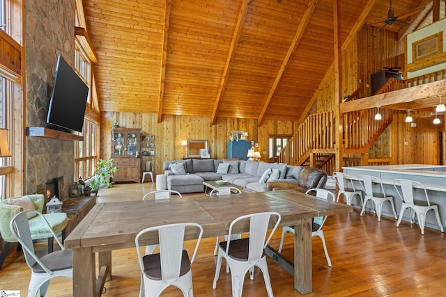 207 Sassafras Dr, Taylors, SC 29687 - dining room featuring high vaulted ceiling, a wooden ceiling with exposed beams, healthy amount of natural light, stairs, and wood walls
