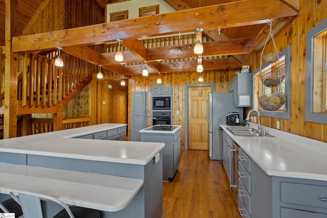 207 Sassafras Dr, Taylors, SC 29687 - kitchen with gray cabinets, black appliances, a kitchen island, wooden walls, and light wood-type flooring