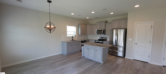 638 Grantleigh Dr, Duncan, SC 29334 - kitchen featuring appliances with stainless steel finishes, light wood-style floors, decorative backsplash, a kitchen island, and a chandelier