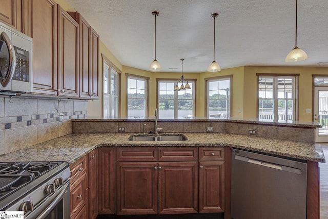 450 Johnson Ave, Anderson, SC 29621 - kitchen with stainless steel appliances, a peninsula, light stone counters, tasteful backsplash, and pendant lighting