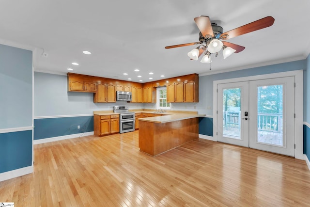 1 Moultrie Dr, Taylors, SC 29687 - kitchen with appliances with stainless steel finishes, a peninsula, ornamental molding, light countertops, and light wood finished floors