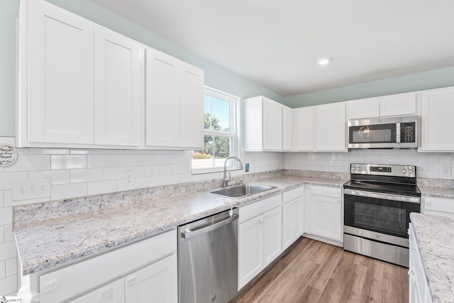 166 Bleckley Trl, Anderson, SC 29625 - kitchen featuring stainless steel appliances, white cabinetry, light wood-type flooring, backsplash, and light stone counters