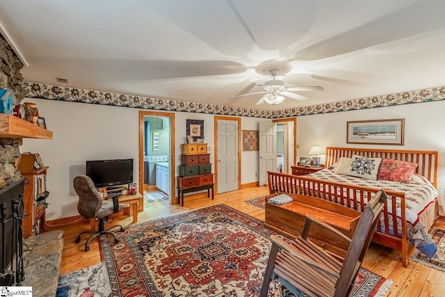 512 Doe Run, Pickens, SC 29671 - bedroom with light wood-style floors, an office area, a ceiling fan, ensuite bath, and a fireplace