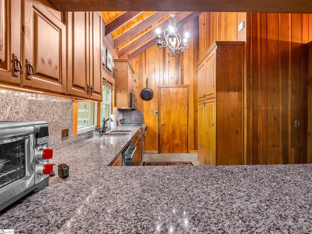 980 Mountain Forest Dr, Union Mills, NC 28167 - kitchen featuring wooden walls, stone countertops, backsplash, a chandelier, and dishwasher