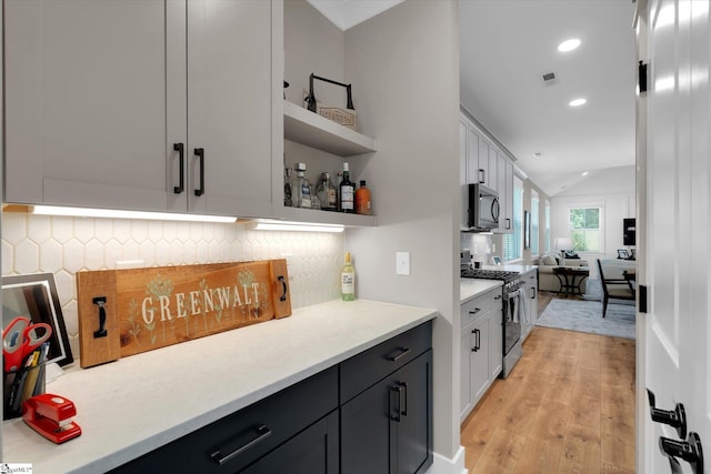 216 Deerview Trl, Simpsonville, SC 29680 - bar featuring appliances with stainless steel finishes, decorative backsplash, light wood-style flooring, vaulted ceiling, and recessed lighting