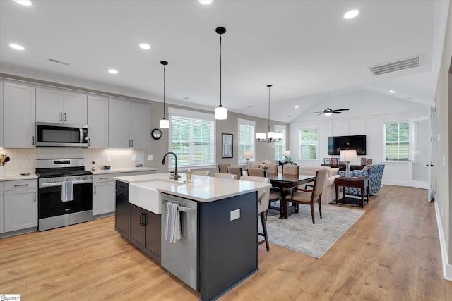 216 Deerview Trl, Simpsonville, SC 29680 - kitchen with appliances with stainless steel finishes, open floor plan, light countertops, light wood-style flooring, and tasteful backsplash