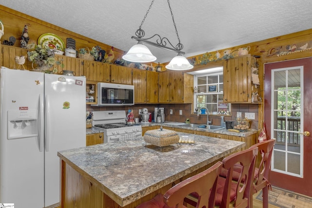 495 Pleasant Grove Rd, Pickens, SC 29671 - kitchen with white appliances, a textured ceiling, brown cabinetry, hanging light fixtures, and a center island