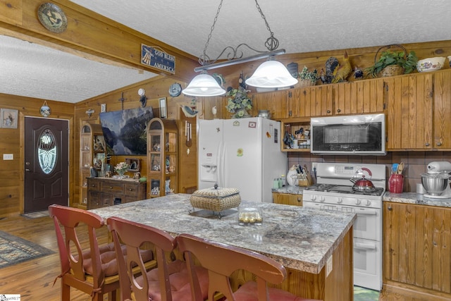 495 Pleasant Grove Rd, Pickens, SC 29671 - kitchen with white appliances, a textured ceiling, wood walls, lofted ceiling, and light wood-style floors