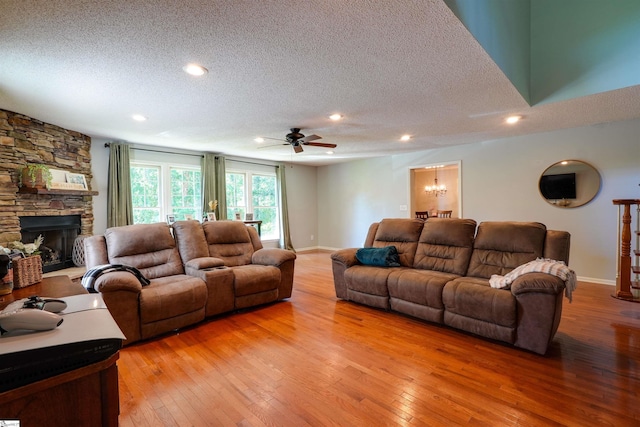 213 Quail Creek Dr, Pickens, SC 29657 - living area featuring a textured ceiling, light wood-style flooring, ceiling fan, a fireplace, and a chandelier