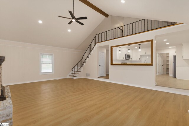 301 Thornwood Dr, Taylors, SC 29687 - unfurnished living room with stairway, light wood finished floors, high vaulted ceiling, ceiling fan, and beam ceiling