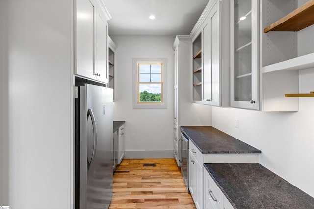 621 Bascule Ridge Ln, Campobello, SC 29322 - kitchen featuring open shelves, freestanding refrigerator, light wood-type flooring, white cabinets, and dark stone countertops