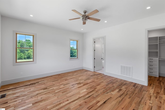 621 Bascule Ridge Ln, Campobello, SC 29322 - unfurnished bedroom featuring multiple windows, a walk in closet, light wood-style flooring, recessed lighting, and a closet