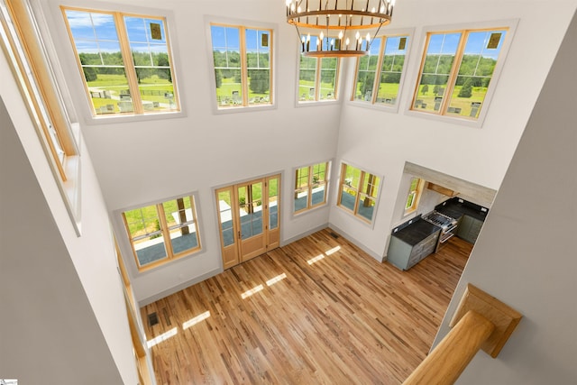 621 Bascule Ridge Ln, Campobello, SC 29322 - unfurnished living room featuring plenty of natural light, a high ceiling, wood finished floors, and a chandelier