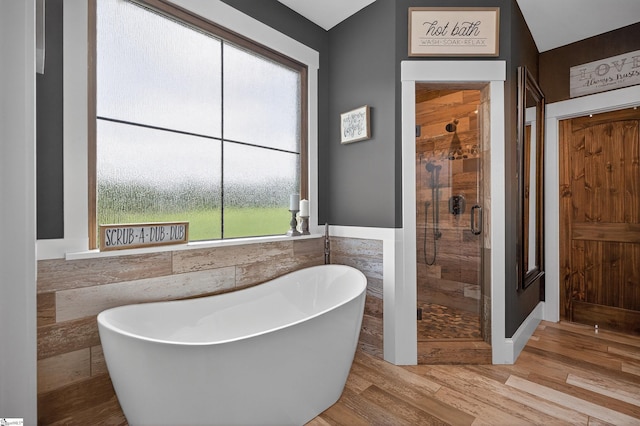 515 Herman Brooks Rd, Belton, SC 29627 - bathroom featuring a stall shower, a soaking tub, wood finished floors, tile walls, and wainscoting