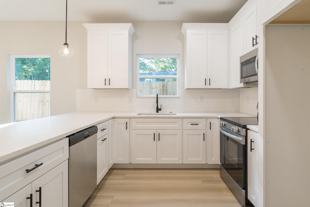 166 Dunbar St, Wellford, SC 29385 - kitchen featuring stainless steel appliances, decorative backsplash, light wood finished floors, and white cabinets