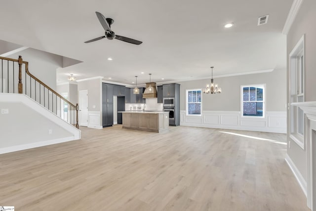 140 Mimosa Rd Lot 27, Inman, SC 29349 - unfurnished living room featuring ornamental molding, a decorative wall, a chandelier, a ceiling fan, and stairway