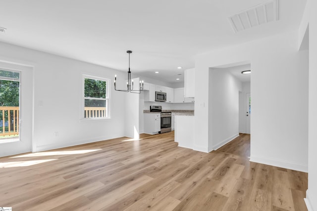 2 Melbourne Ln, Greenville, SC 29615 - unfurnished living room featuring plenty of natural light, light wood-style floors, a chandelier, and recessed lighting