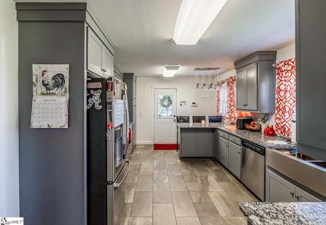 849 Harvey Rd, Greer, SC 29651 - kitchen with appliances with stainless steel finishes, a peninsula, gray cabinets, hanging light fixtures, and dark stone counters