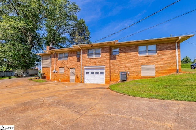 849 Harvey Rd, Greer, SC 29651 - rear view of house featuring driveway, a garage, a chimney, a yard, and brick siding