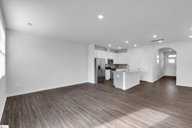 313 E Compass Way, Easley, SC 29640 - kitchen featuring appliances with stainless steel finishes, open floor plan, arched walkways, recessed lighting, and a center island with sink