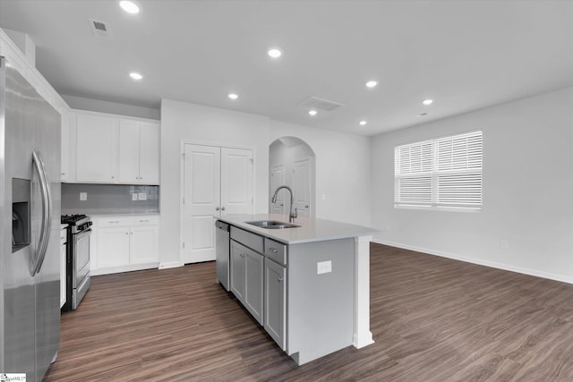 313 E Compass Way, Easley, SC 29640 - kitchen featuring stainless steel appliances, arched walkways, dark wood-style floors, a kitchen island with sink, and white cabinets