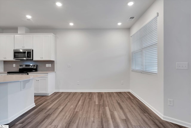 292 E Compass Way, Easley, SC 29640 - kitchen with appliances with stainless steel finishes, wood finished floors, light countertops, white cabinetry, and recessed lighting