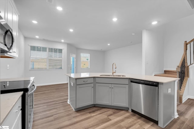 292 E Compass Way, Easley, SC 29640 - kitchen featuring appliances with stainless steel finishes, light wood-type flooring, gray cabinetry, an island with sink, and recessed lighting