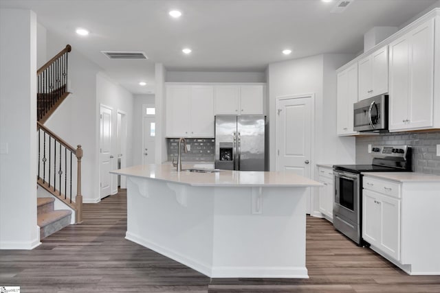 292 E Compass Way, Easley, SC 29640 - kitchen with appliances with stainless steel finishes, tasteful backsplash, a kitchen island with sink, dark wood-style flooring, and recessed lighting