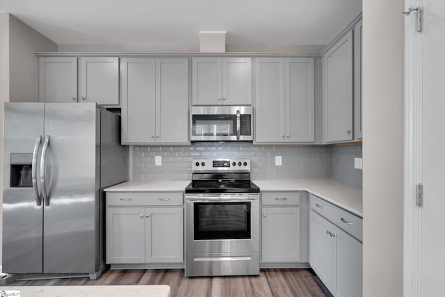 291 E Compass Way, Easley, SC 29640 - kitchen featuring appliances with stainless steel finishes, light countertops, light wood-style floors, and decorative backsplash