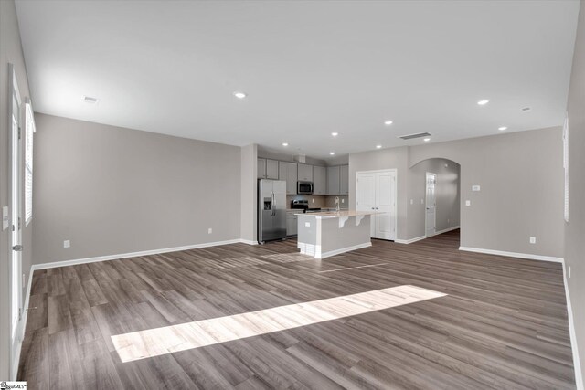 291 E Compass Way, Easley, SC 29640 - unfurnished living room with arched walkways, wood finished floors, and recessed lighting