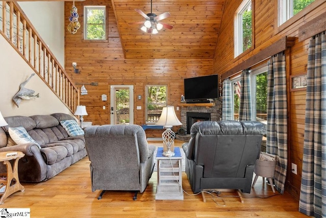 215 Serenity Bay Dr, Seneca, SC 29672 - living room featuring a high ceiling, healthy amount of natural light, wood walls, a fireplace, and ceiling fan