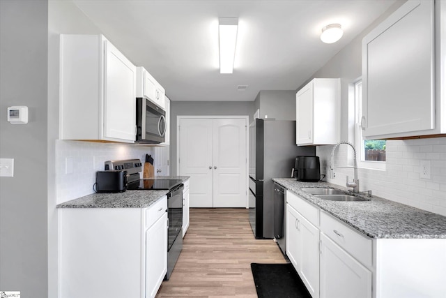 209 Long Grove Ln, Greer, SC 29650 - kitchen featuring appliances with stainless steel finishes, tasteful backsplash, light wood-type flooring, and white cabinetry