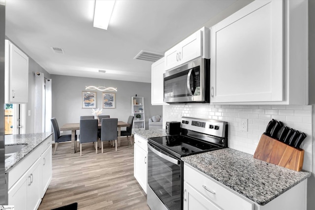 209 Long Grove Ln, Greer, SC 29650 - kitchen featuring stainless steel appliances, backsplash, light wood-style floors, white cabinetry, and light stone counters