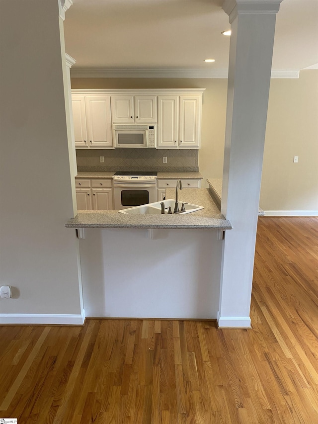 523 Meadowsweet Ln, Greenville, SC 29615 - kitchen featuring white appliances, crown molding, white cabinets, a peninsula, and backsplash